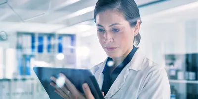 Shot of a young woman using a digital tablet in a lab, demonstrating the use of AI in science
