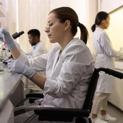 Scientist in a wheelchair working in a disability-inclusive laboratory