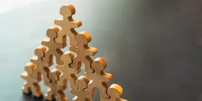 Wooden figures representing teamwork and leadership skills for lab managers