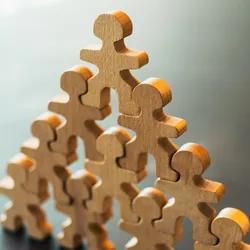 Wooden figures representing teamwork and leadership skills for lab managers