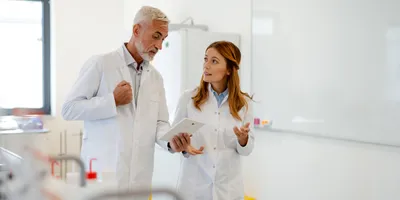 Two lab professionals discussing feedback in a lab environment