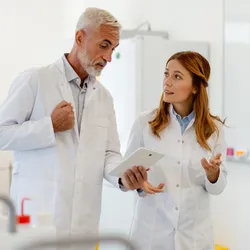 Two lab professionals discussing feedback in a lab environment