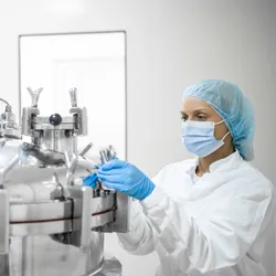 Scientist working on biopharma manufacturing equipment