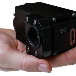 A close-up of a person's open palm holding a compact, black industrial device, identified as the Horiba PoliSpectra H27.