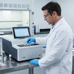 A forensic laboratory professional carefully loads a trace evidence sample into a thermal analysis instrument. The workspace is equipped with both DSC and TGA machines, along with evidence bags containing samples awaiting analysis, highlighting the scientific process of material identification.