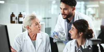 A trio of laboratory staff representing different age generations