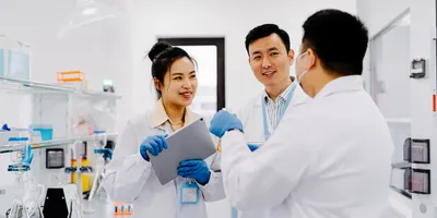 A lab manager listening to two other staff members, showing the benefits of quiet leadership attributes