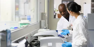 Lab technicians discussing lab equipment validation procedures