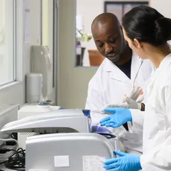 Lab technicians discussing lab equipment validation procedures
