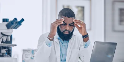 Lab technician showing signs of workplace stress