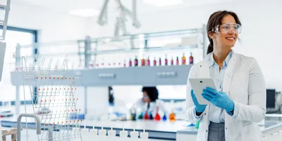 Woman in a lab coat and safety gear engaged during Lab Safety Awareness Week