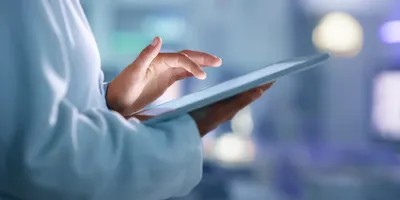 Hand holding a tablet, indicating laboratory automation