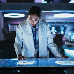 Scientist using a digital screen for data analysis in a lab setting.
