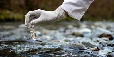 Scientist collecting water sample for trifluoroacetic acid testing