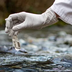 Scientist collecting water sample for trifluoroacetic acid testing