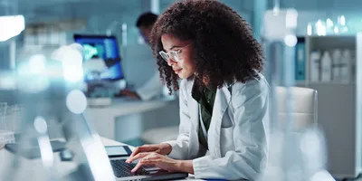 Lab technician analyzing data using AI in a laboratory