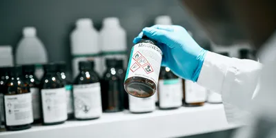 Lab technician reviewing a chemical bottle during laboratory chemical management