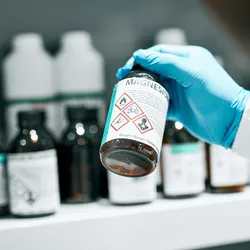 Lab technician reviewing a chemical bottle during laboratory chemical management