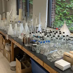 Table filled with various lab equipment and glassware promoting lab equipment reuse.