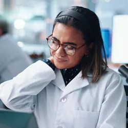 Laboratory worker experiencing shoulder discomfort, highlighting RSI risks