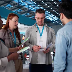 Four attendees networking and talking during an industry conference on the exhibitor floor.