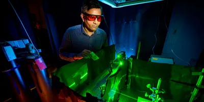 Researcher using laser for plasmonic chemistry experiments