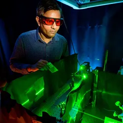 Researcher using laser for plasmonic chemistry experiments