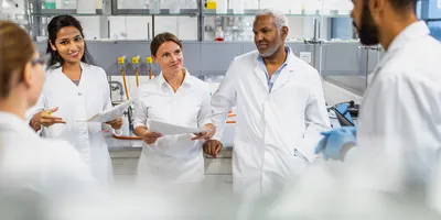 Five laboratory staff having a group meeting in the lab.