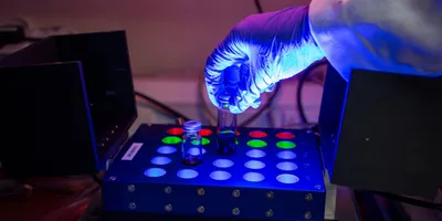 A researcher performing late-stage functionalization with a light-powered setup.