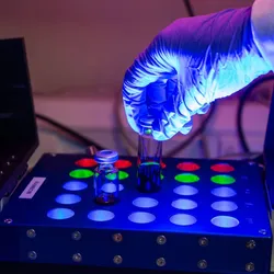 A researcher performing late-stage functionalization with a light-powered setup.