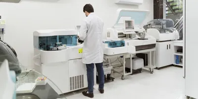 Male researcher in a laboratory working, standing next to a machine.