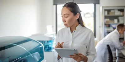 An attentive scientist with a tablet, absorbed in work within a laboratory setting