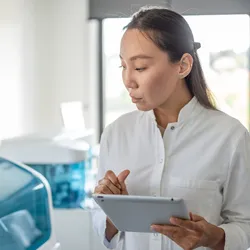 An attentive scientist with a tablet, absorbed in work within a laboratory setting