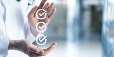 Three checkmarks with hands around them, representing regulatory compliance