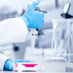 Scientist using a pipette at a lab bench