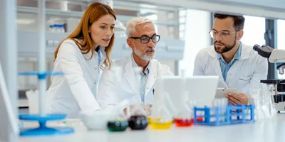 Scientists sharing critical knowledge in a lab setting
