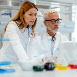 Scientists sharing critical knowledge in a lab setting
