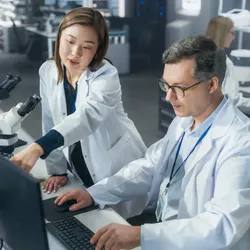 Scientists collaborating in a laboratory setting on AI-related projects