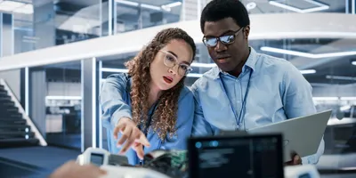 Two lab professionals discussing work during management by walking around