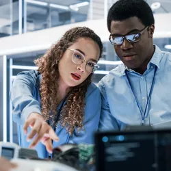 Two lab professionals discussing work during management by walking around