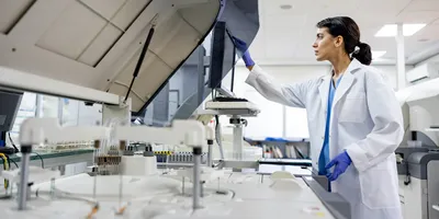 Female researcher examining laboratory instrument