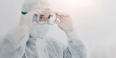Worker adjusting PPE goggles for safety compliance