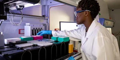 A female scientist working in a laboratory, she is using a machine to carry out research.