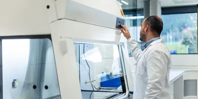 Lab professional adjusting equipment for energy efficiency.