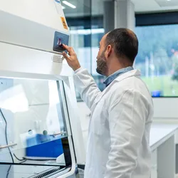 Lab professional adjusting equipment for energy efficiency.