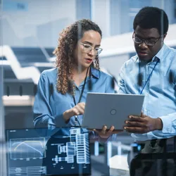 Lab scientists discussing service contracts over a laptop