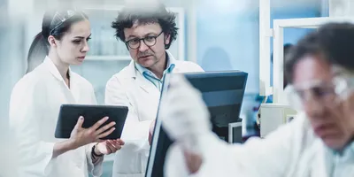 Researchers analyzing data on antimicrobial resistance in a lab.