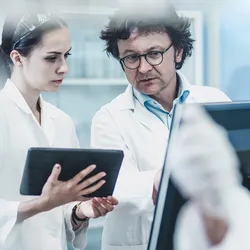 Researchers analyzing data on antimicrobial resistance in a lab.