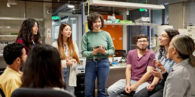 Lab manager leading a discussion with students in a laboratory setting.