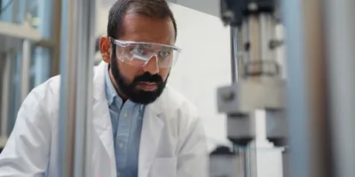 A young ethnic male scientist is doing research and working in a laboratory.
